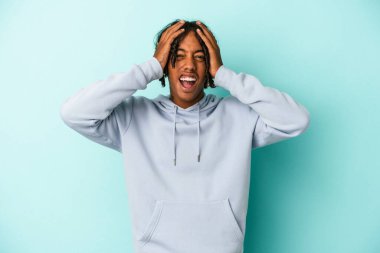 Genç Afrikalı Amerikalı adam mavi arka planda izole edilmiş bağırıyor, çok heyecanlı, tutkulu, bir şeyden memnun..