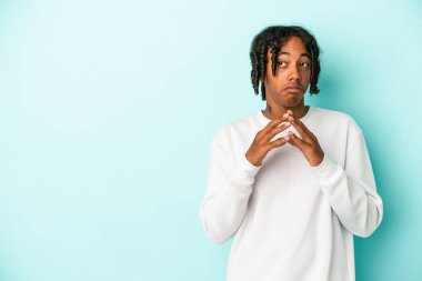 Genç Afro-Amerikalı adam mavi arka planda izole edildi. Aklında bir plan oluşturdu..