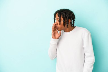 Mavi arka planda izole edilmiş genç Afro-Amerikan bir adam gizli bir sıcak fren haberi söylüyor.