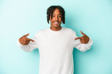 Genç Afrikalı Amerikalı adam mavi arka planda izole edilmiş. Parmakları aşağıda..