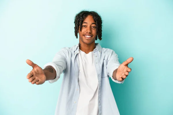 Joven Afroamericano Aislado Sobre Fondo Azul Mostrando Una Expresión Bienvenida —  Fotos de Stock