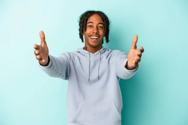 Jovem Afro Americano Isolado Fundo Azul Sente Confiante Dando Abraço — Fotografia de Stock