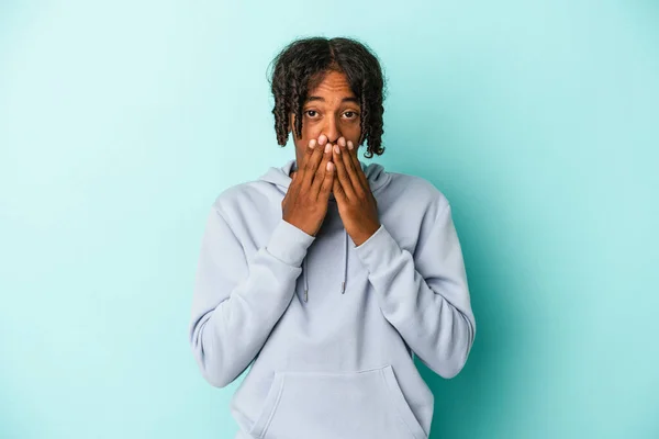 Ung Afrikansk Amerikansk Man Isolerad Blå Bakgrund Chockad Täcker Munnen — Stockfoto