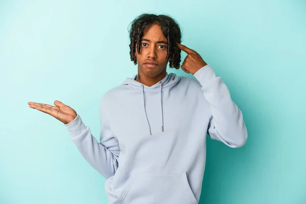 Young African American Man Isolated Blue Background Holding Showing Product — Stock Photo, Image