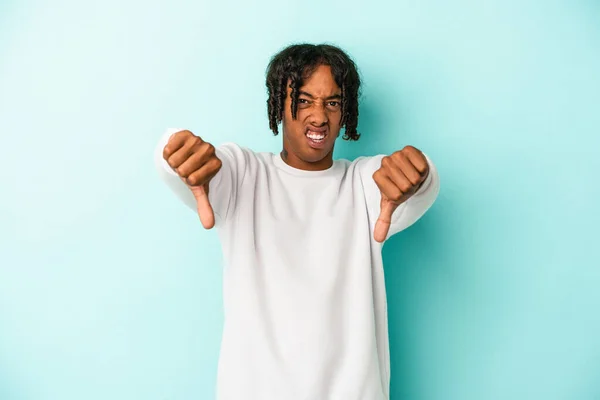 親指を立てて嫌悪を表現する青い背景に隔離された若いアフリカ系アメリカ人男性 — ストック写真