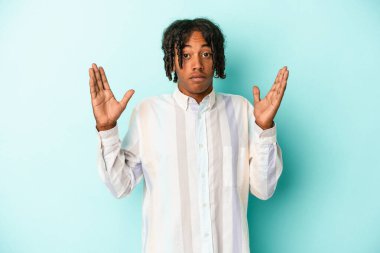 Genç Afrikalı Amerikalı bir adam mavi arka planda izole edilmiş. Bir fikri, ilham verici bir konsepti var..