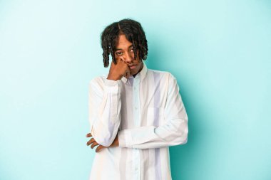 Genç Afrikalı Amerikalı adam mavi arka planda izole edilmiş. Tekrarlanan bir görevden yorulmuş..