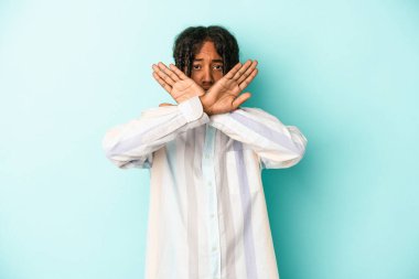 Genç Afrikalı Amerikalı adam mavi arka planda izole edilmiş bir şekilde inkar jesti yapıyor.