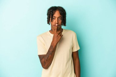Genç Afrikalı Amerikalı adam mavi arka planda izole edilmiş düşünüyor ve yukarı bakıyor, yansıtıyor, düşünüyor, hayal kuruyor..