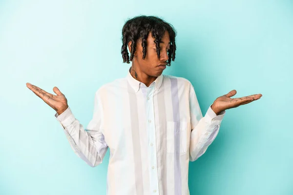 Mladý Africký Američan Izolovaný Modrém Pozadí Zmatené Pochybné Pokrčení Ramen — Stock fotografie