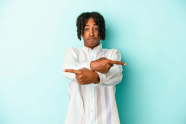 Fiatal Afro Amerikai Férfi Elszigetelt Kék Háttér Pontok Oldalra Próbál — Stock Fotó