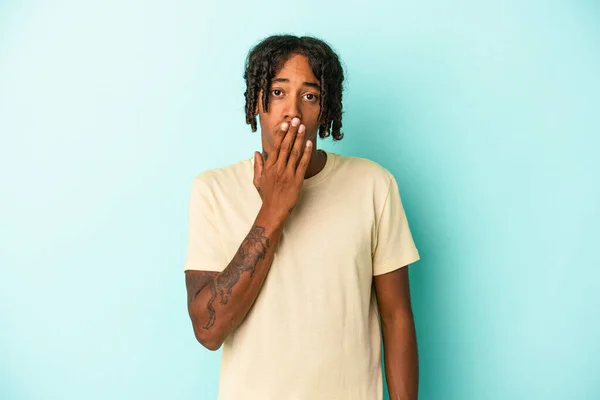 Ung Afrikansk Amerikansk Man Isolerad Blå Bakgrund Chockad Täcker Munnen — Stockfoto