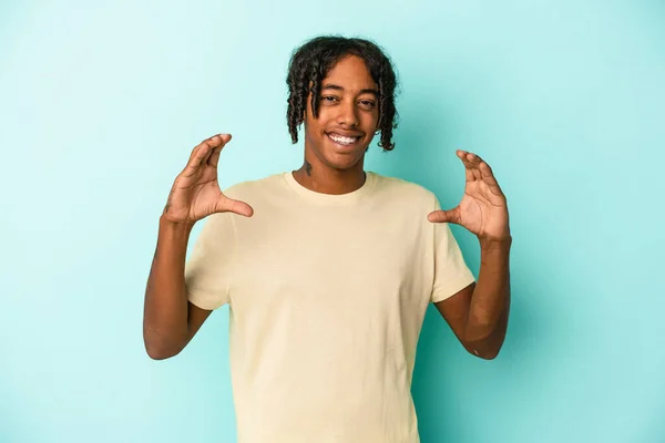 Junger Afrikanisch Amerikanischer Mann Isoliert Auf Blauem Hintergrund Hält Etwas — Stockfoto