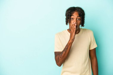 Mavi arka planda izole edilmiş genç Afro-Amerikan bir adam gizli bir sıcak fren haberi söylüyor.