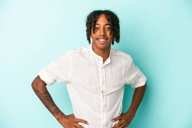 Genç Afrikalı Amerikalı adam mavi arka planda izole edilmiş mutlu, güler yüzlü ve neşeli..
