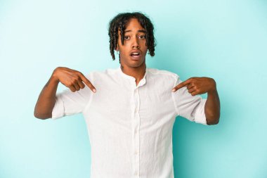 Genç Afrikalı Amerikalı adam mavi arka planda izole edilmiş. Parmakları aşağıda..