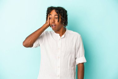 Genç Afrikalı Amerikalı bir adam mavi arka planda izole edilmiş, şok olmuştu, önemli bir toplantıyı hatırladı..