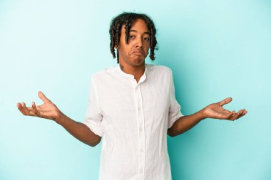Genç Afrikalı Amerikalı adam mavi arka planda izole edilmiş sorgulama jestinde şüphe ediyor ve omuz silkiyor..