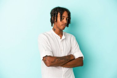 Genç Afrikalı Amerikalı bir adam mavi arka planda izole edilmiş şüpheli, belirsiz, seni inceliyor..