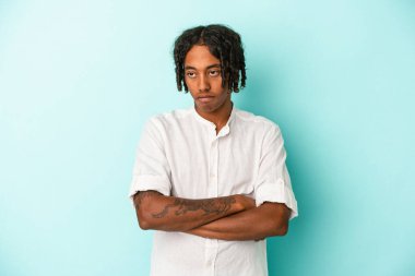 Genç Afrikalı Amerikalı adam mavi arka planda izole edilmiş. Tekrarlanan bir görevden yorulmuş..