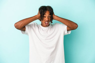 Genç Afrikalı Amerikalı adam mavi arka planda izole edilmiş bağırıyor, çok heyecanlı, tutkulu, bir şeyden memnun..