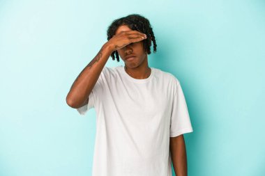 Genç Afrikalı Amerikalı adam mavi arka planda izole edilmiş tapınaklara dokunuyor ve baş ağrısı çekiyor..