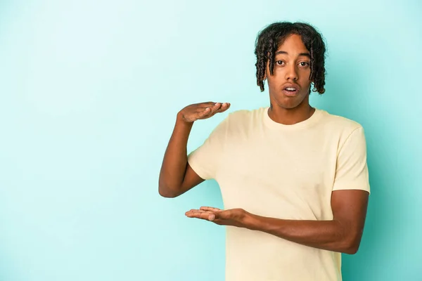 Young African American Man Isolated Blue Background Shocked Amazed Holding — Stock Photo, Image