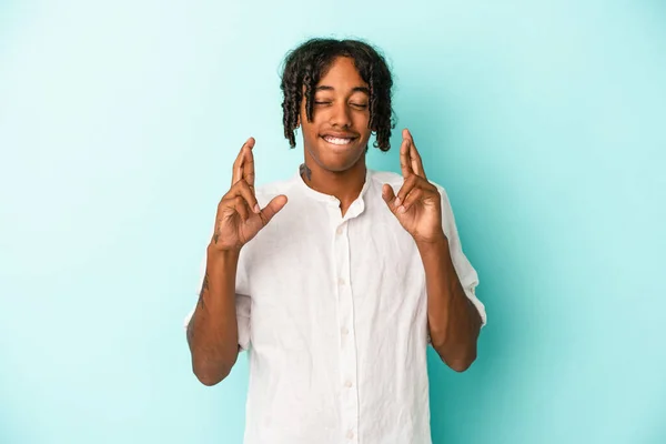 Fiatal Afro Amerikai Férfi Elszigetelt Kék Háttér Keresztbe Ujjait Mert — Stock Fotó