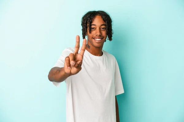 年轻的非洲裔美国人 身披蓝色背景 快乐无忧无虑 用手指展示和平的象征 — 图库照片