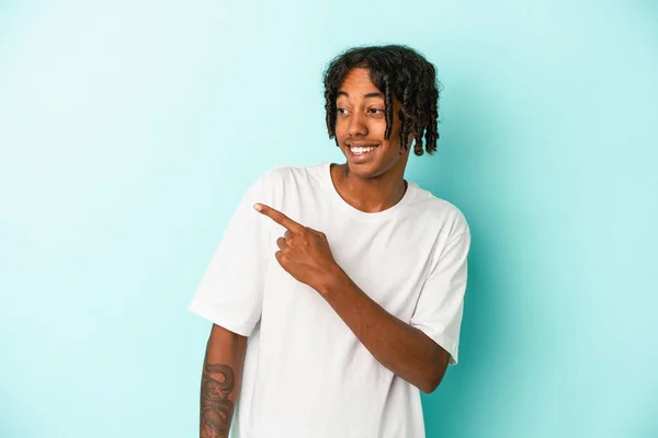 Jovem Afro Americano Isolado Fundo Azul Olha Para Lado Sorridente — Fotografia de Stock