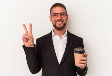Elinde beyaz arka planda izole edilmiş kahveleri alıp götüren beyaz iş adamı neşeli ve kaygısız parmaklarıyla barış sembolü gösteriyor..
