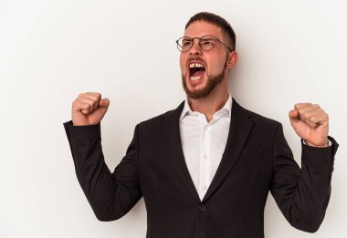 Beyaz arka planda izole genç beyaz adam zafer, kazanan konsept sonra yumruk kaldırma.