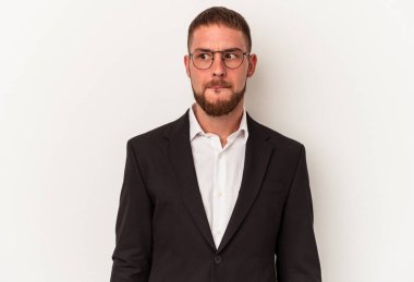 Beyaz arka planda soyutlanmış, kafası karışmış, şüpheci ve kararsız genç beyaz bir adam..