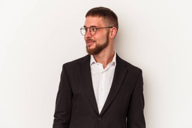 Beyaz arka planda soyutlanmış genç beyaz bir adam gülümsüyor, neşeli ve keyifli görünüyor..