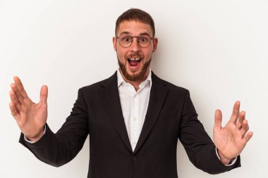 Beyaz arka planda izole genç beyaz adam hoş bir sürpriz alıyor, heyecanlı ve el kaldırıyor..