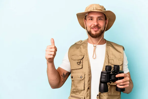 Ung Kaukasier Man Tittar Djur Genom Kikare Isolerad Blå Bakgrund — Stockfoto