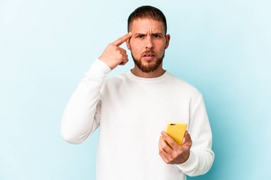 Mavi arka planda cep telefonu tutan beyaz bir adam işaret parmağıyla yaptığı hayal kırıklığını gösteriyor..