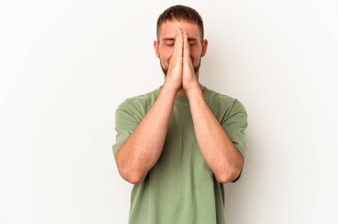 Beyaz arka planda izole edilmiş beyaz tenli genç beyaz bir adam el ele tutuşarak dua ediyor, kendine güveniyor..