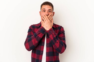 Beyaz arka planda izole edilmiş beyaz tenli genç beyaz adam elleriyle ağzını kapatarak şoka girdi..