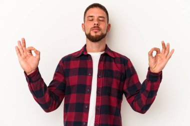 Diastema hastası genç beyaz arka planda izole edilmiş çalışkan bir günün ardından dinleniyor. Yoga yapıyor..