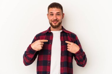 Beyaz arka planda izole edilmiş beyaz tenli genç beyaz adam parmağını göstererek şaşırdı ve gülümsedi..