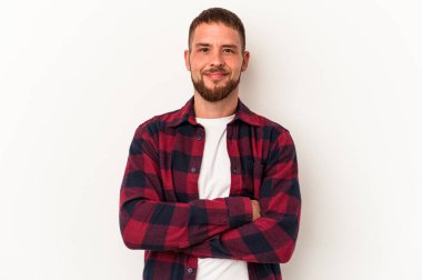 Diasteması olan beyaz tenli genç bir adam beyaz arka planda izole edilmiş, kendinden emin, kararlılıkla kollarını kavuşturuyor..