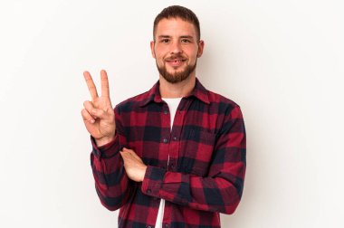 Diastemalı beyaz bir adam beyaz arka planda iki numarayı parmaklarıyla gösteriyor..