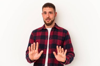 Diastemalı beyaz bir adam beyaz arka planda izole edilmiş, tiksinti belirtisi gösteren birini reddediyor..