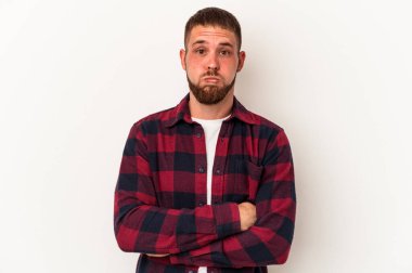 Beyaz arka planda izole edilmiş beyaz tenli genç beyaz adam yanakları patlatıyor, yorgun bir ifadeye sahip. Yüz ifadesi kavramı.