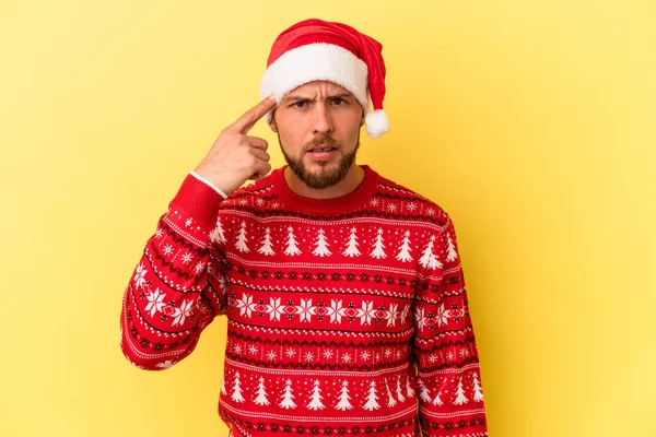 Sarı arka planda izole edilmiş genç beyaz adam işaret parmağıyla hayal kırıklığı jesti gösteriyor..