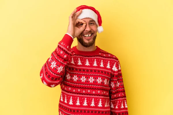 Genç beyaz adam Noel 'i kutluyor. Sarı arka planda yalnız. Heyecanlı..