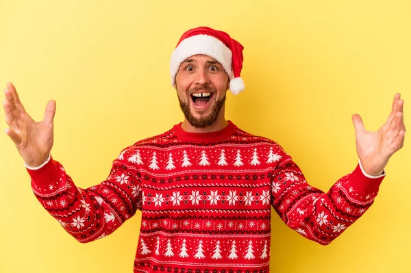 年轻的高加索人在黄色背景下孤立无援地庆祝圣诞节 他得到了一个愉快的惊喜 兴奋地举起双手 — 图库照片