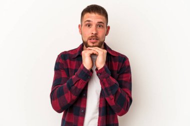 Beyaz arka planda izole edilmiş beyaz tenli genç beyaz bir adam şans için dua ediyor, şaşırıyor ve ağzını açıyor..