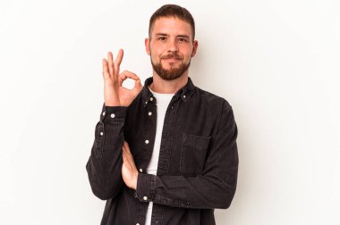 Diasteması olan beyaz tenli genç beyaz bir adam göz kırptı ve elleriyle iyi bir jest yaptı..